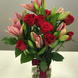 Bouquet of red roses and pink lilies in a glass vase