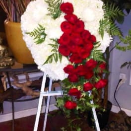 Heart-shaped floral spray of white and red roses on an easel