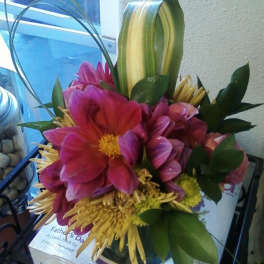 Bouquet of pink and yellow flowers with looping green leaves