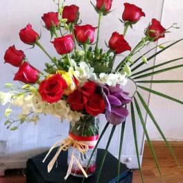 Bouquet of red roses with white and purple flowers in a glass vase