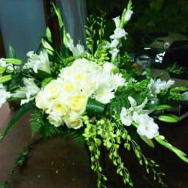 White floral spray with roses and lilies arranged in a low, wide design