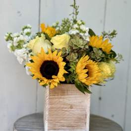 Sunflowers and pale yellow roses in a wooden box arrangement