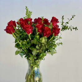 Red roses arranged in a clear glass vase