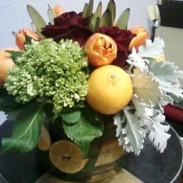 Bouquet of roses, tulips, hydrangea, and citrus in a vase