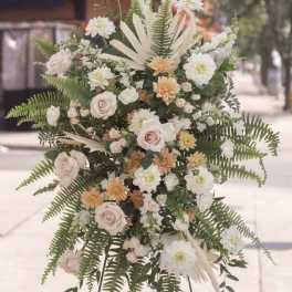 Standing floral spray with white and blush flowers on an easel