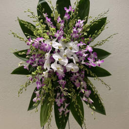 Tall orchid arrangement with white and purple blooms on a stand