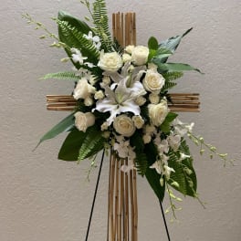 White floral arrangement on a bamboo cross stand