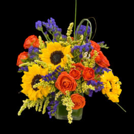 Bouquet of sunflowers and orange roses in a glass vase