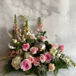 Pink and white floral arrangement with roses and tall blooms around a metallic orb