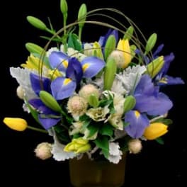 Bouquet of blue and yellow flowers in a square vase