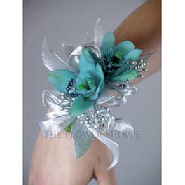 Blue floral wrist corsage with silver ribbon on a person's wrist