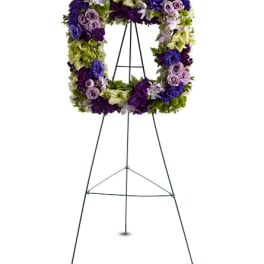 Purple and green floral wreath on a black easel