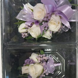 White rose corsages with lavender ribbon and small purple filler flowers
