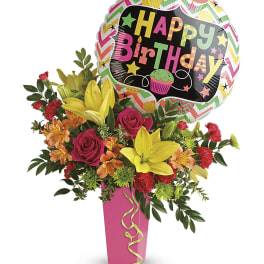 Birthday bouquet with roses, lilies, and a balloon in a pink vase