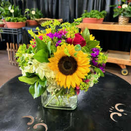 Sunflower and rose bouquet in a square glass vase