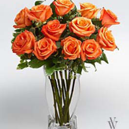 Orange roses arranged in a clear glass vase