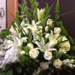 White floral arrangement with lilies and roses in a vase