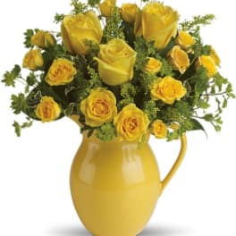 Yellow roses arranged in a yellow pitcher vase