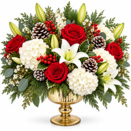 Red roses and white lilies in a gold vase with pinecones