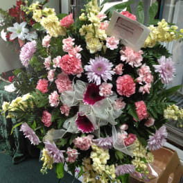 Large standing floral spray with pink, lavender, and yellow blooms