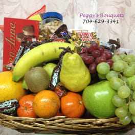 Fruit basket with candy bars, grapes, bananas, pears, oranges, and apples