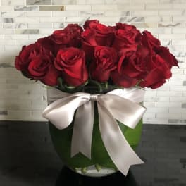 Bouquet of red roses in a glass vase with a satin ribbon