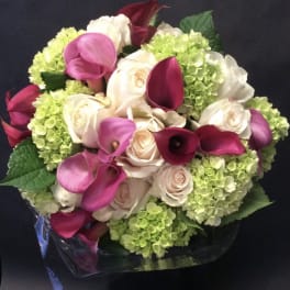 Bouquet of pink calla lilies, white roses, and green hydrangeas