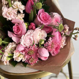 Pink mixed bouquet with roses and tulip buds wrapped in brown paper