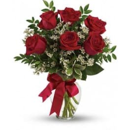 Red roses in a glass vase with a red ribbon