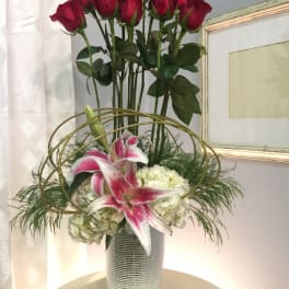 Tall vase arrangement with red roses, pink lilies, and white hydrangeas