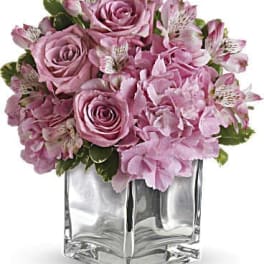 Pink roses and alstroemeria in a clear square vase