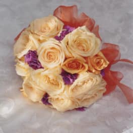 Cream rose bouquet with purple accents and orange ribbon