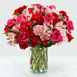 Pink and red mixed bouquet in a clear glass vase