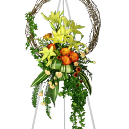 Floral standing wreath with yellow lilies and orange roses on an easel
