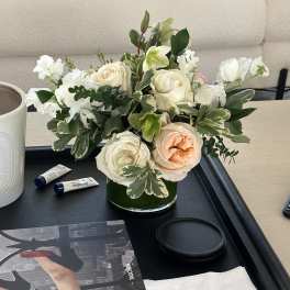 White and peach roses arranged in a low glass vase