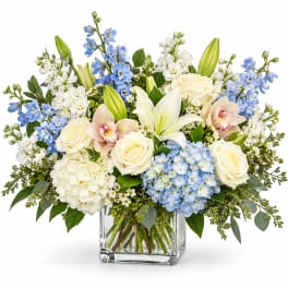 Blue and white floral arrangement in a clear glass vase