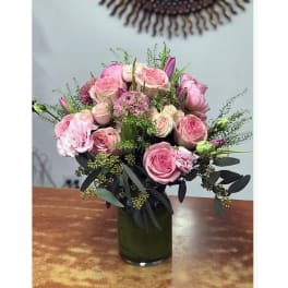 Pink rose bouquet in a green glass vase