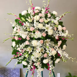 Large standing spray of white and pale pink flowers on an easel
