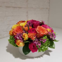 Colorful rose arrangement in a white bowl vase