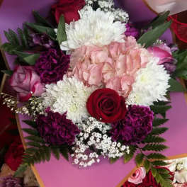 Bouquet of pink, white, and red flowers wrapped in pink paper