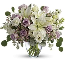 Lavender roses and white lilies in a clear glass vase