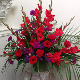 Tall red and purple floral arrangement in a vase