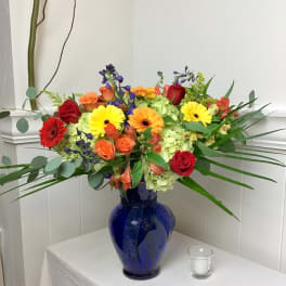 Colorful mixed bouquet in a blue glass vase