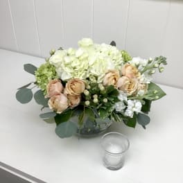 Peach roses and white hydrangeas in a glass bowl vase