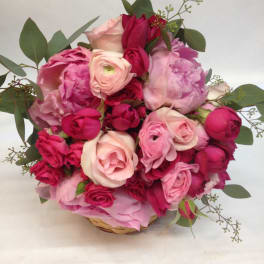 Pink and red rose bouquet in a woven basket