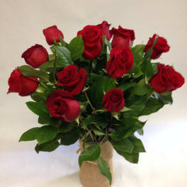Bouquet of red roses in a burlap-wrapped vase