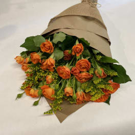 Bouquet of orange roses wrapped in brown paper