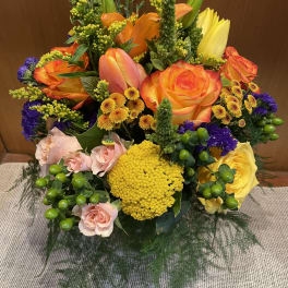 Bright mixed bouquet with orange and yellow roses and pink blooms