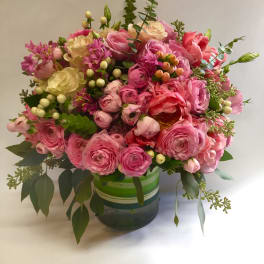 Pink and cream bouquet in a striped glass vase