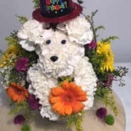 White floral dog arrangement with a glittery birthday hat and colorful flowers